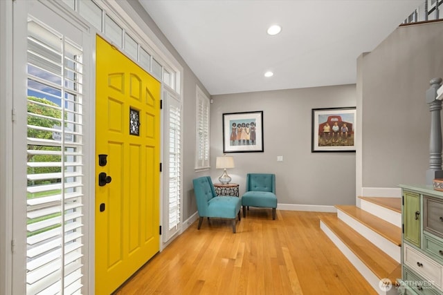 foyer featuring baseboards, light wood-style flooring, recessed lighting, and stairs