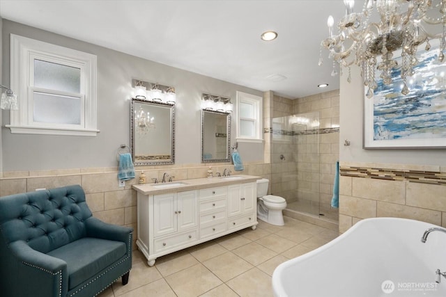 full bath featuring tile walls, tile patterned floors, a soaking tub, a tile shower, and double vanity