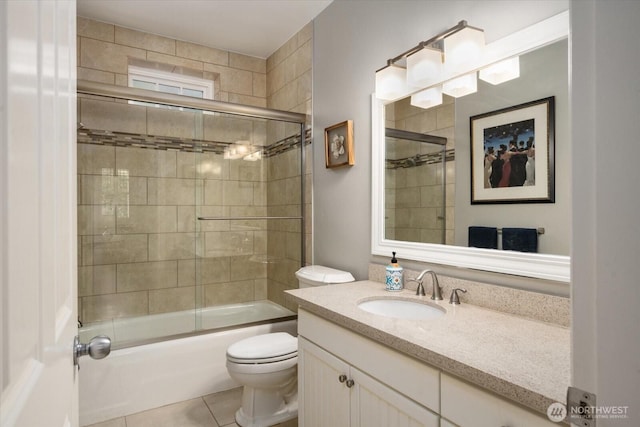 bathroom with toilet, vanity, shower / bath combination with glass door, and tile patterned flooring