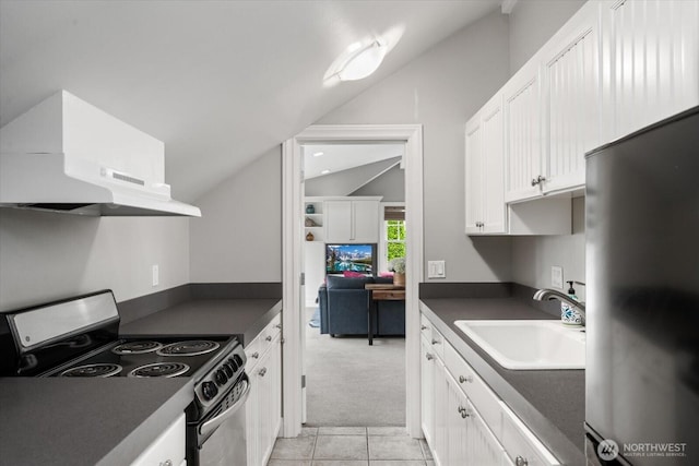 kitchen with appliances with stainless steel finishes, a sink, vaulted ceiling, under cabinet range hood, and dark countertops