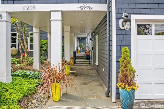 doorway to property featuring a porch and a garage