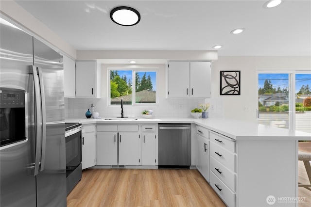 8716 Main St, Edmonds, WA 98026 - kitchen with appliances with stainless steel finishes, a peninsula, light countertops, backsplash, and recessed lighting