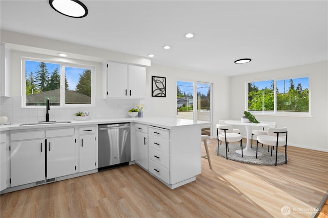 8716 Main St, Edmonds, WA 98026 - kitchen with dishwasher, a peninsula, light wood finished floors, light countertops, and backsplash