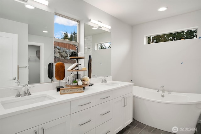 8112 131st Pl SE Unit 15, Snohomish, WA 98296 - bathroom with double vanity, a freestanding bath, recessed lighting, and a spacious closet