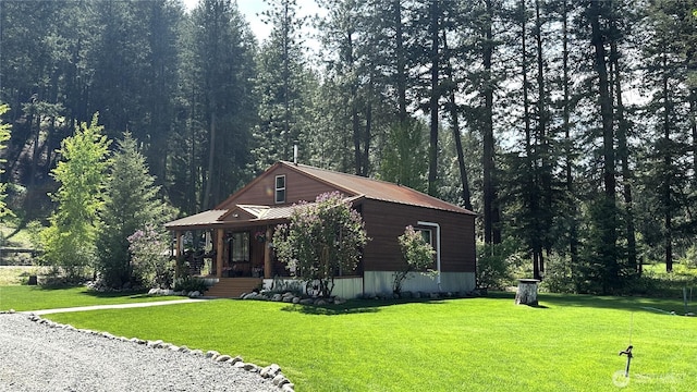 26 Newby Creek Rd, Twisp, WA 98856 - view of front of home with covered porch, a front yard, metal roof, and a view of trees