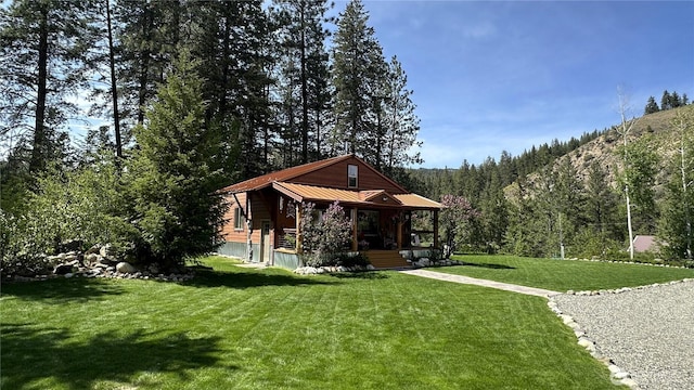 26 Newby Creek Rd, Twisp, WA 98856 - view of green lawn with covered porch and a view of trees
