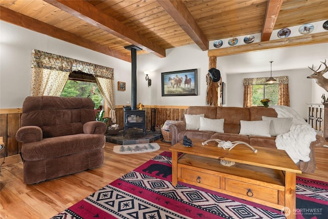 26 Newby Creek Rd, Twisp, WA 98856 - living room featuring a wood stove, a wooden ceiling with exposed beams, wainscoting, wood finished floors, and wooden walls