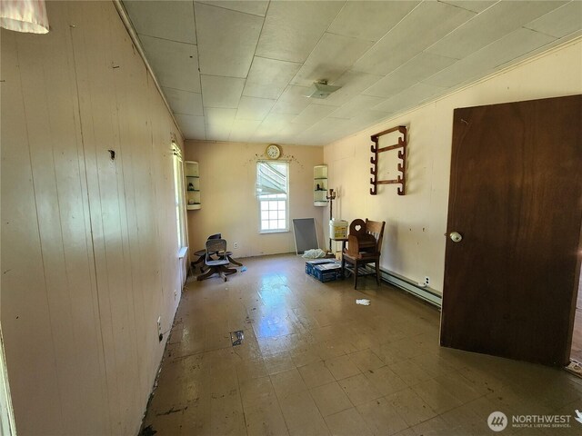175 Stevens Rd, Chehalis, WA 98532 - unfurnished room featuring a baseboard radiator, wood walls, and tile patterned floors