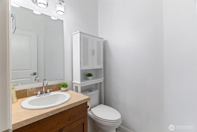 half bath featuring toilet and vanity