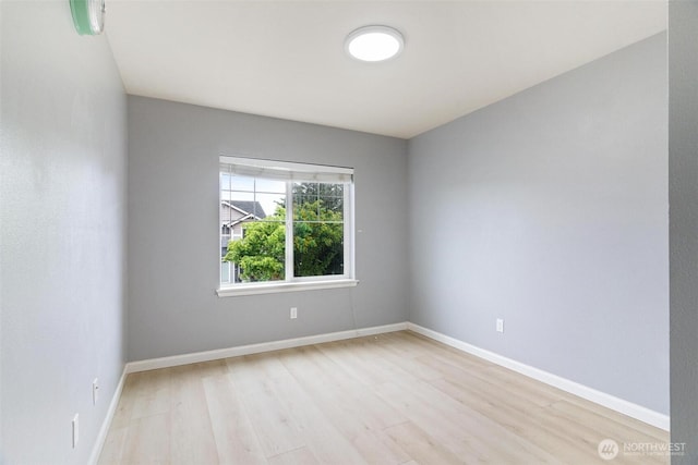 empty room with light wood-style flooring and baseboards