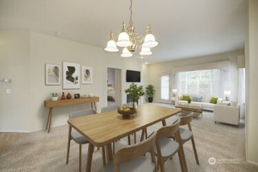 dining area with a chandelier and light colored carpet