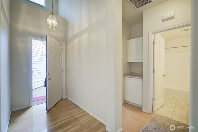 foyer entrance with light wood-type flooring, healthy amount of natural light, and baseboards