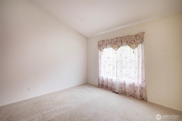 carpeted empty room with vaulted ceiling