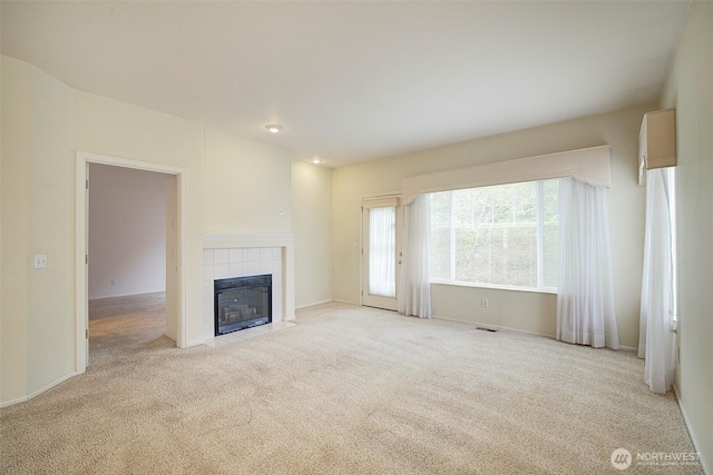 unfurnished living room featuring carpet floors, a fireplace, and baseboards