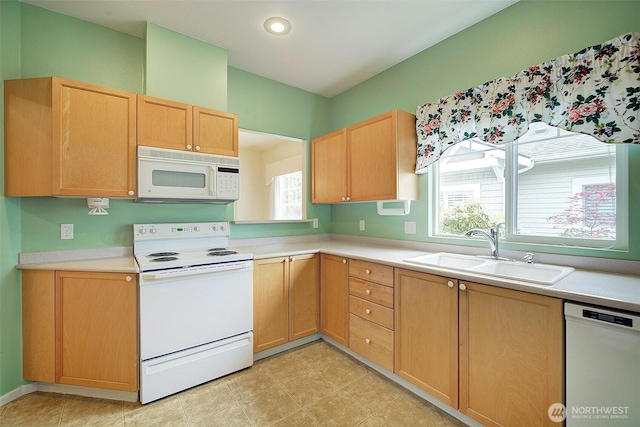 kitchen with white appliances, a sink, light countertops, light brown cabinets, and recessed lighting