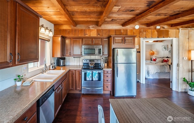 1011 231st Ln, Ocean Park, WA 98640 - kitchen featuring stainless steel appliances, wood ceiling with exposed beams, dark wood finished floors, a sink, and brown cabinetry
