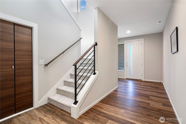 stairs featuring wood finished floors, baseboards, and recessed lighting