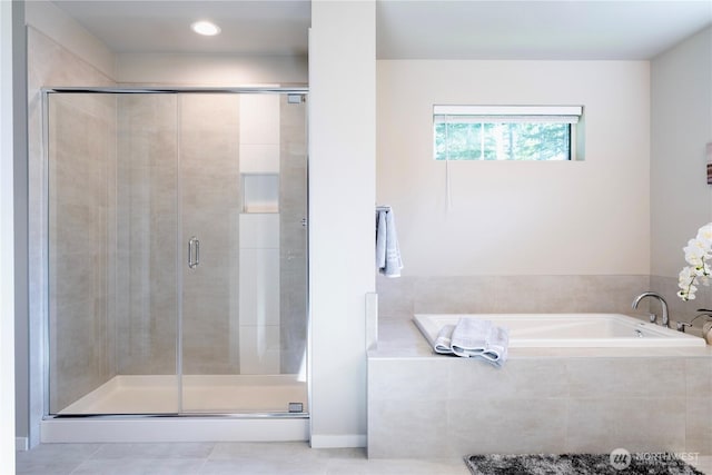 full bathroom featuring a shower stall, a bath, and tile patterned flooring