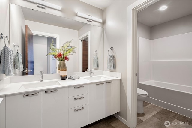 full bath featuring toilet and double vanity
