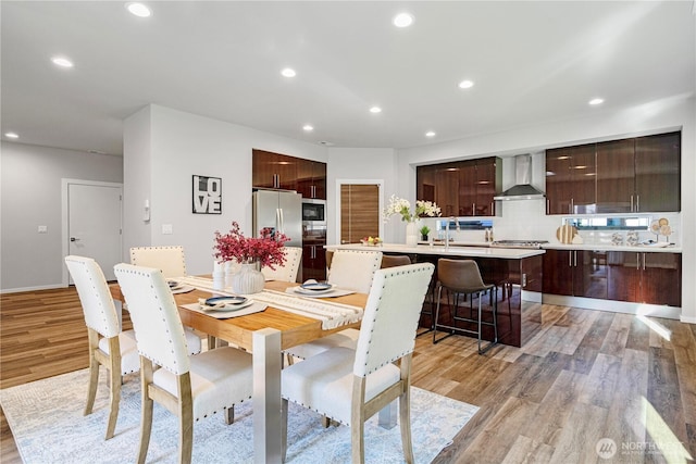 dining space with light wood-type flooring and recessed lighting
