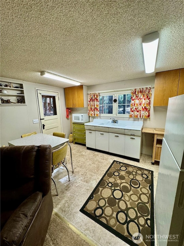 511 Old River Rd Unit 18, Naches, WA 98937 - kitchen featuring white appliances, light countertops, white cabinets, a textured ceiling, and brown cabinetry