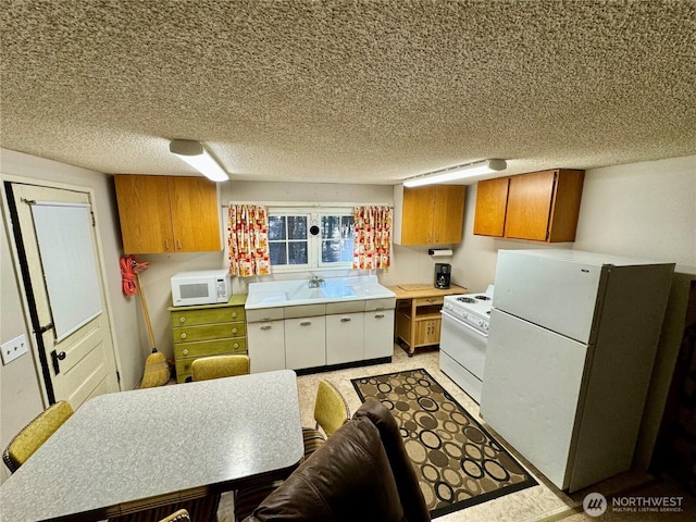 511 Old River Rd Unit 18, Naches, WA 98937 - kitchen featuring white appliances, brown cabinets, light countertops, a sink, and a textured ceiling