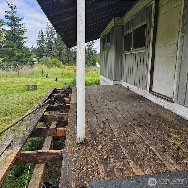 wooden deck featuring a lawn