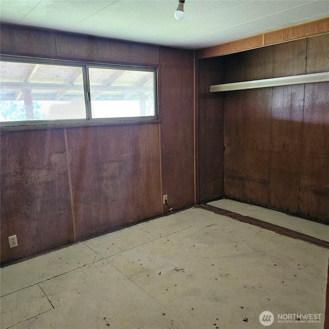 unfurnished bedroom with wood walls