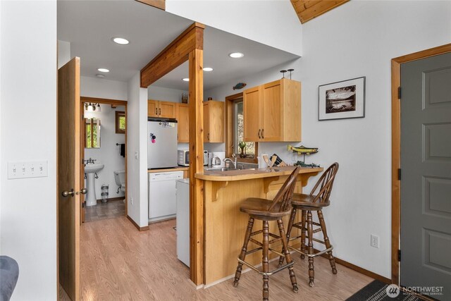 6166 Westside Rd, Cle Elum, WA 98922 - kitchen with white dishwasher, light wood-style floors, a kitchen bar, freestanding refrigerator, and recessed lighting