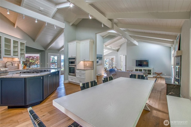376 Killebrew Lake Rd, Orcas Island, WA 98280 - kitchen featuring rail lighting, open floor plan, appliances with stainless steel finishes, white cabinetry, and backsplash