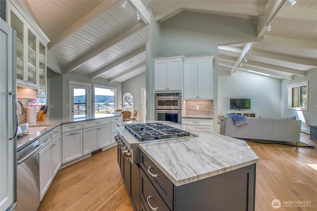 376 Killebrew Lake Rd, Orcas Island, WA 98280 - kitchen with rail lighting, stainless steel appliances, open floor plan, white cabinetry, and beamed ceiling