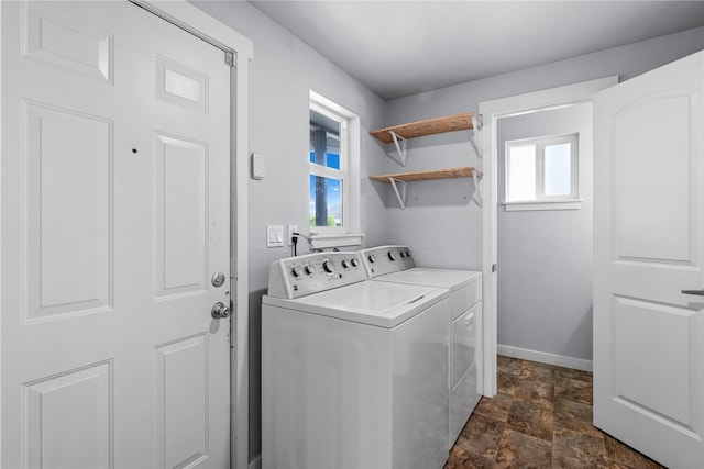 washroom featuring separate washer and dryer, healthy amount of natural light, stone finish flooring, and baseboards