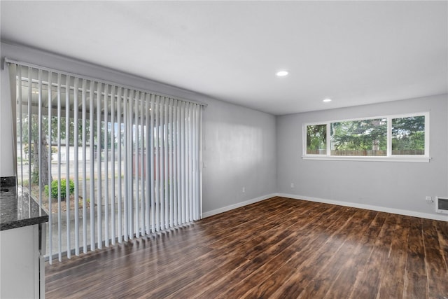 unfurnished room with wood finished floors, baseboards, and recessed lighting