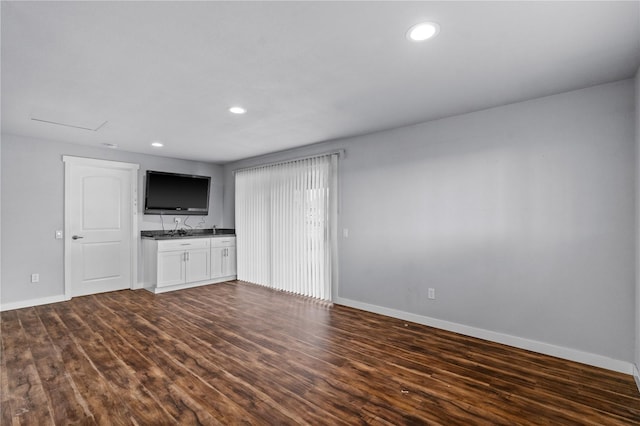 unfurnished living room featuring baseboards, dark wood finished floors, and recessed lighting