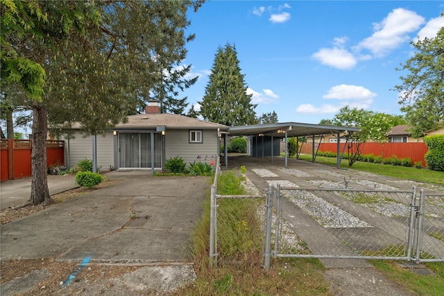 view of front of property with driveway, a gate, fence, and a chimney