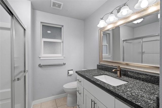 bathroom featuring tile patterned floors, a stall shower, vanity, toilet, and baseboards