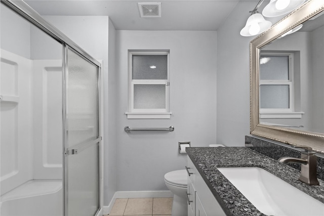 full bath featuring a shower stall, tile patterned floors, baseboards, toilet, and vanity