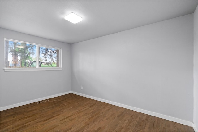 empty room with baseboards and dark wood-style flooring