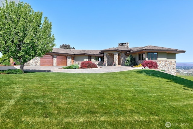 1041 Red Sky Dr, Yakima, WA 98903 - view of front facade featuring stone siding, a front yard, an attached garage, a chimney, and driveway