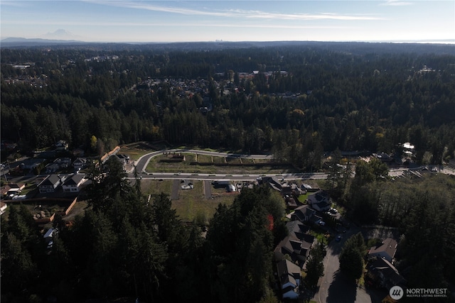 aerial view of property and surrounding area with a heavily wooded area