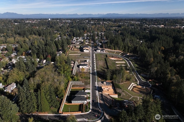 aerial view of property's location with a heavily wooded area and mountains