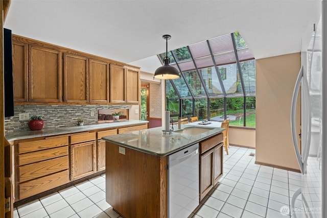14413 139th Ave SE, Snohomish, WA 98290 - kitchen with stainless steel dishwasher, fridge, light tile patterned floors, decorative backsplash, and brown cabinets