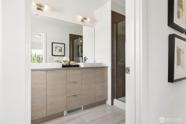full bath featuring double vanity and a shower stall