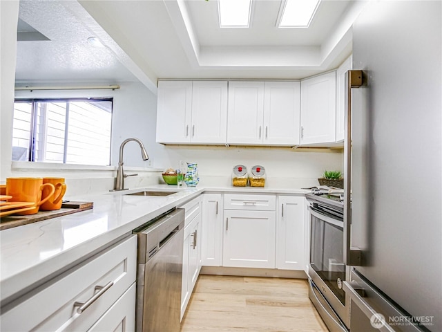 8407 18th Ave W Unit 4-102, Everett, WA 98204 - kitchen featuring stainless steel appliances, a sink, light wood-type flooring, and white cabinetry