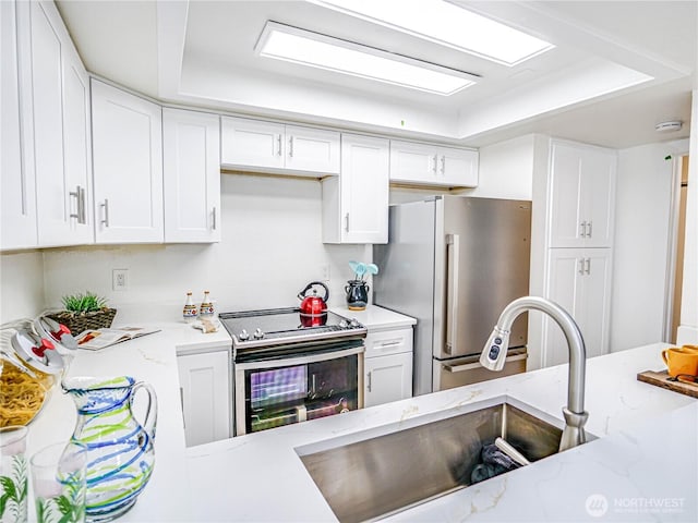 8407 18th Ave W Unit 4-102, Everett, WA 98204 - kitchen featuring stainless steel appliances, a sink, white cabinetry, and light stone countertops