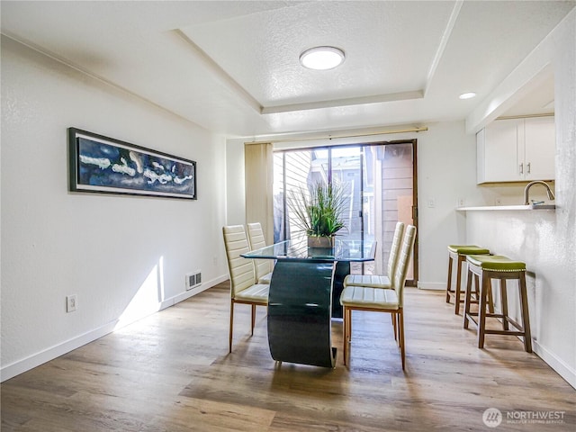 8407 18th Ave W Unit 4-102, Everett, WA 98204 - dining room featuring a tray ceiling, wood finished floors, and baseboards