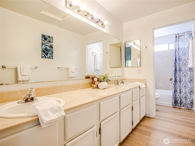 8407 18th Ave W Unit 4-102, Everett, WA 98204 - bathroom featuring double vanity, wood finished floors, shower / bath combo with shower curtain, and toilet