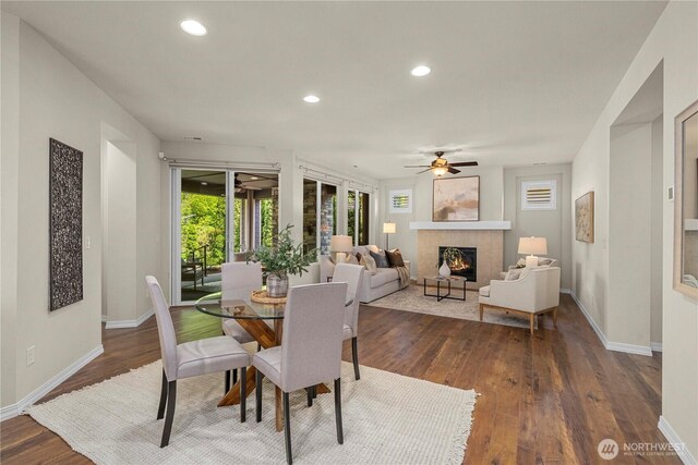 14419 190th Avenue Ct E, Bonney Lake, WA 98391 - dining area with ceiling fan, a fireplace, baseboards, dark wood-style floors, and recessed lighting