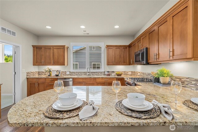 14419 190th Avenue Ct E, Bonney Lake, WA 98391 - kitchen with appliances with stainless steel finishes, a sink, light stone countertops, brown cabinetry, and recessed lighting