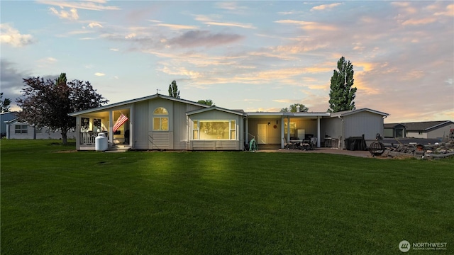 10615 SE Handicap Dr, Warden, WA 98857 - back of house at dusk with a lawn and a patio